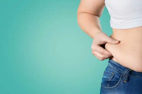 Image of woman pinching her love handles to show weight gain Mansfield